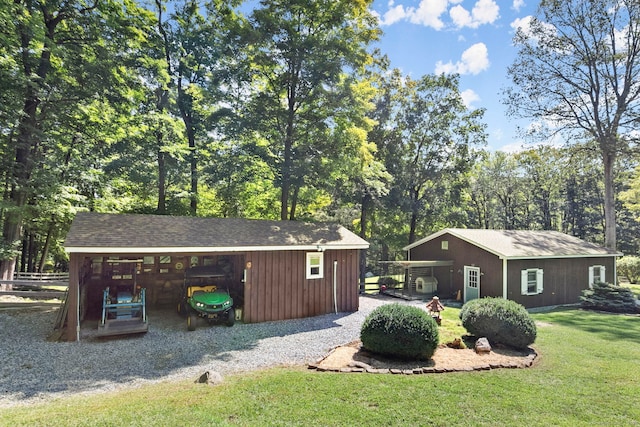 exterior space with an outbuilding, fence, and a lawn