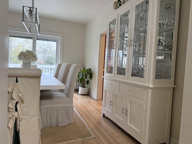 dining space featuring light wood-style floors and baseboards