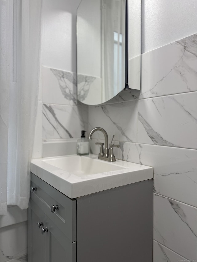 bathroom featuring vanity, backsplash, and tile walls