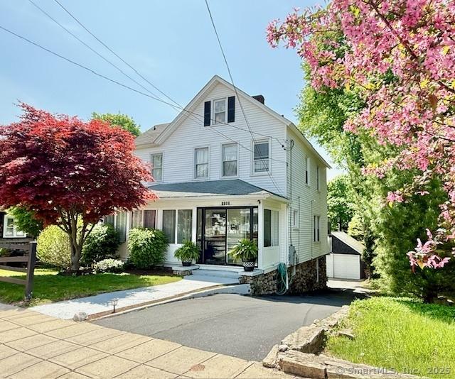 view of front of house featuring a garage and an outbuilding