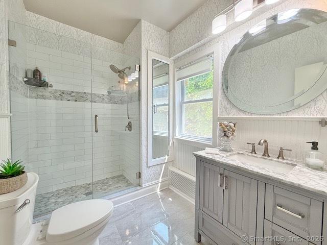 full bathroom featuring vanity, a shower stall, toilet, and a garden tub