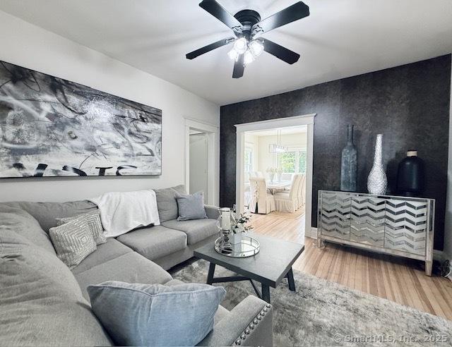 living room with ceiling fan and wood finished floors