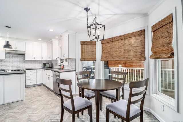 5A Big Buck Ln, Brookfield, CT 06804 - kitchen with dark countertops, under cabinet range hood, crown molding, stainless steel dishwasher, and decorative backsplash
