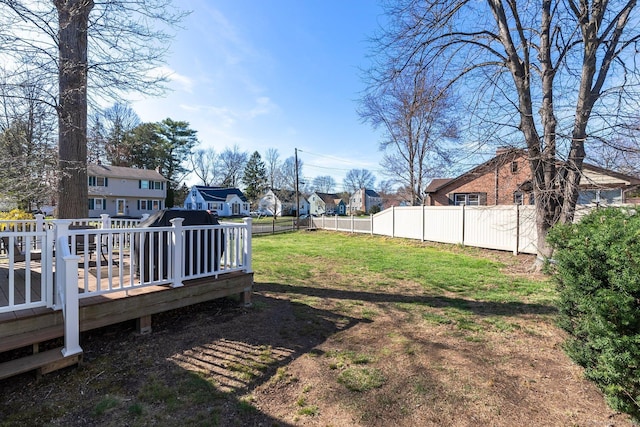 view of yard featuring a wooden deck, a fenced backyard, and a residential view