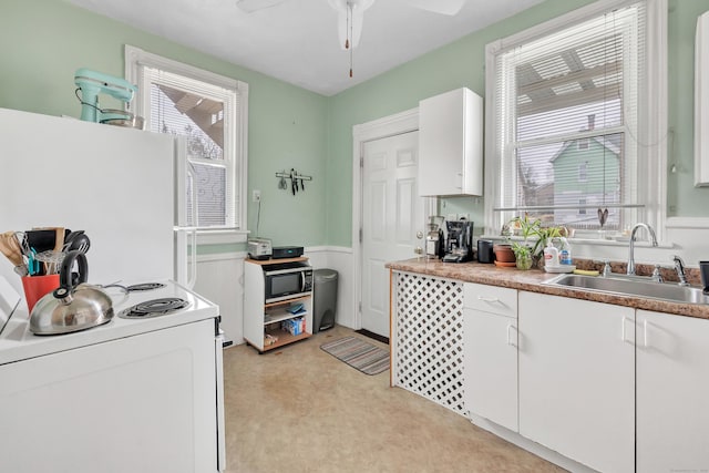 172 Prospect Ave, Shelton, CT 06484 - kitchen with white cabinets, a sink, ceiling fan, white appliances, and wainscoting