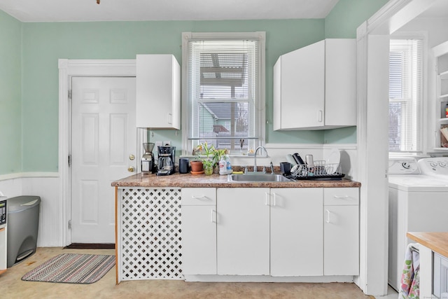 172 Prospect Ave, Shelton, CT 06484 - kitchen with washer / clothes dryer, a sink, white cabinets, and plenty of natural light