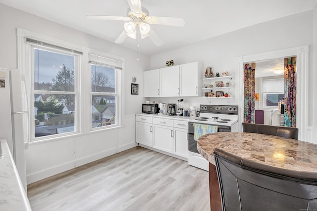 172 Prospect Ave, Shelton, CT 06484 - kitchen with ceiling fan, white appliances, white cabinets, light countertops, and light wood finished floors
