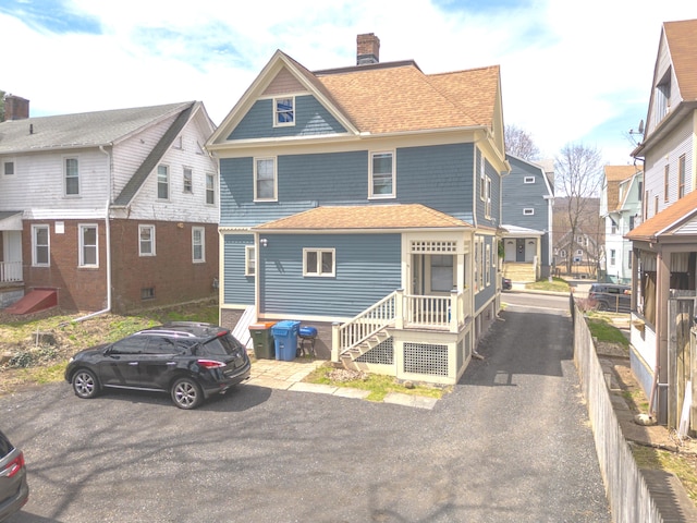 exterior space featuring a chimney and a shingled roof