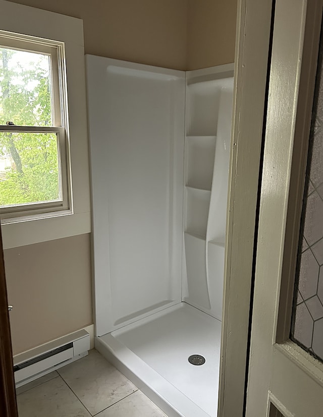 bathroom featuring a shower stall, a baseboard radiator, and marble finish floor