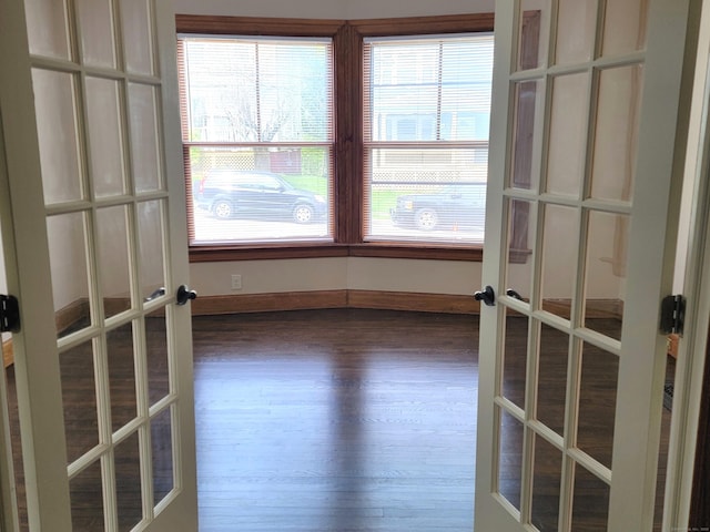 spare room with french doors, baseboards, and dark wood finished floors