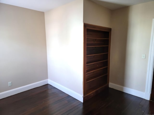 interior space featuring baseboards and dark wood finished floors