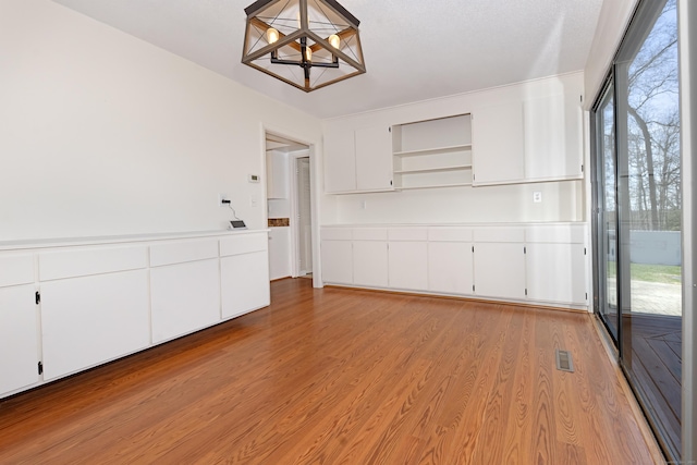 170 Barker Hill Dr, Guilford, CT 06437 - unfurnished dining area with light wood-type flooring and a chandelier