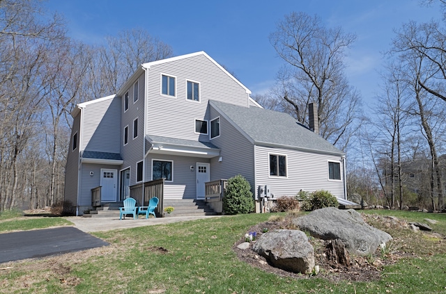 170 Barker Hill Dr, Guilford, CT 06437 - back of property with a chimney, a lawn, and a shingled roof