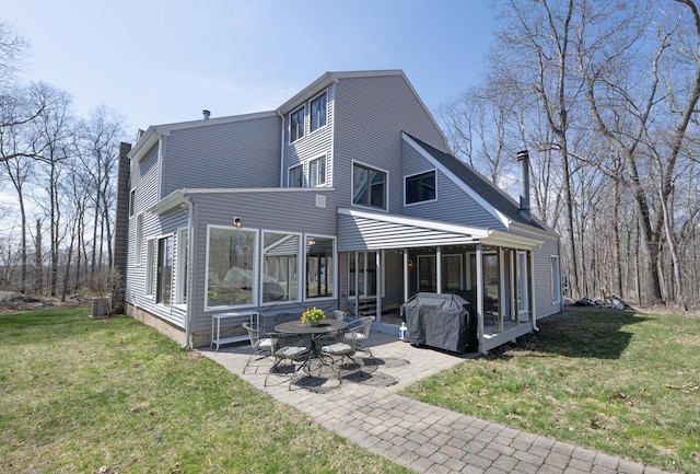 170 Barker Hill Dr, Guilford, CT 06437 - back of property with a chimney, a patio area, a yard, and a sunroom