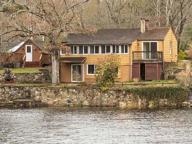 24 Echo Point Rd, Guilford, CT 06437 - view of front of home featuring a chimney, a shingled roof, and a deck with water view