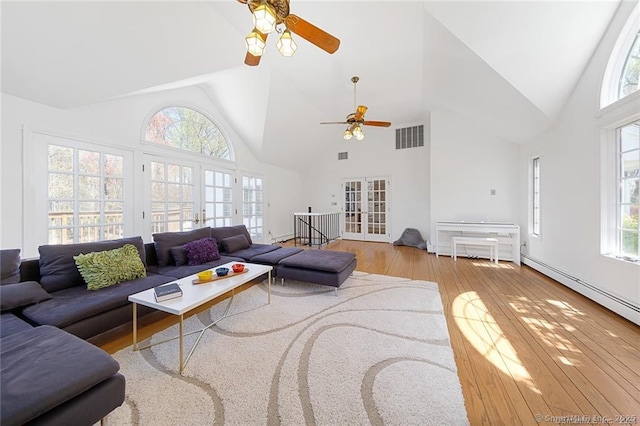 living area with visible vents, high vaulted ceiling, hardwood / wood-style flooring, french doors, and a ceiling fan