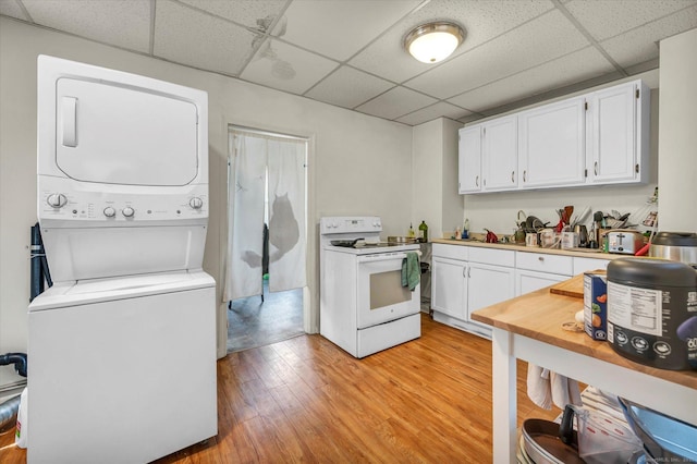 clothes washing area with stacked washing maching and dryer, laundry area, and light wood-style floors
