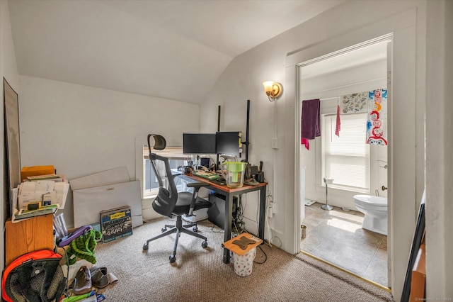 carpeted home office featuring lofted ceiling