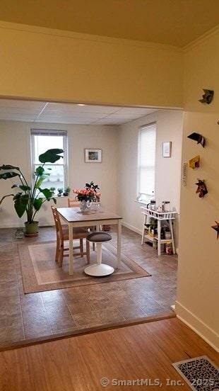 dining area with baseboards, a healthy amount of sunlight, wood finished floors, and visible vents