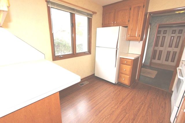112 Paugassett Ln Unit 112, Shelton, CT 06484 - kitchen with freestanding refrigerator, dark wood-style flooring, brown cabinetry, and light countertops