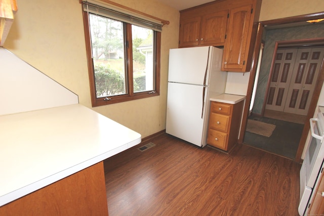 112 Paugassett Ln Unit 112, Shelton, CT 06484 - kitchen with freestanding refrigerator, brown cabinets, dark wood-style flooring, light countertops, and range