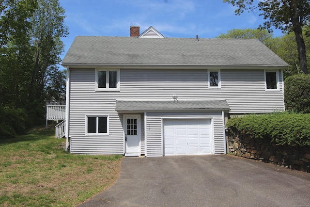 112 Paugassett Ln Unit 112, Shelton, CT 06484 - view of front of property featuring a chimney, an attached garage, a shingled roof, stairs, and a front yard