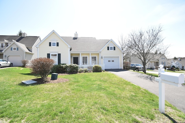 traditional home with a residential view, a chimney, driveway, an attached garage, and a front yard