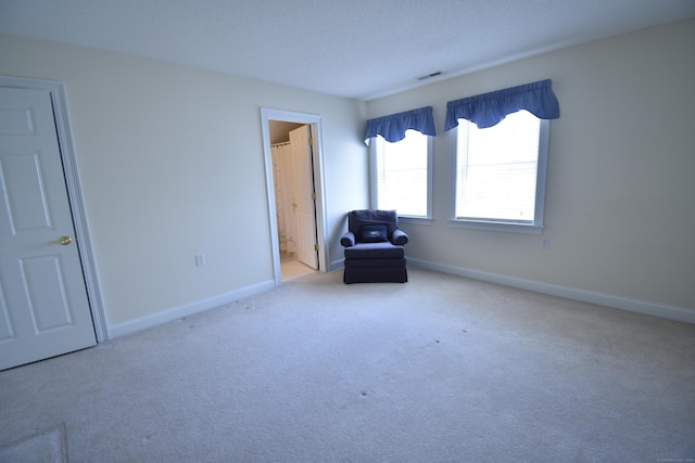 unfurnished room featuring carpet, visible vents, and baseboards