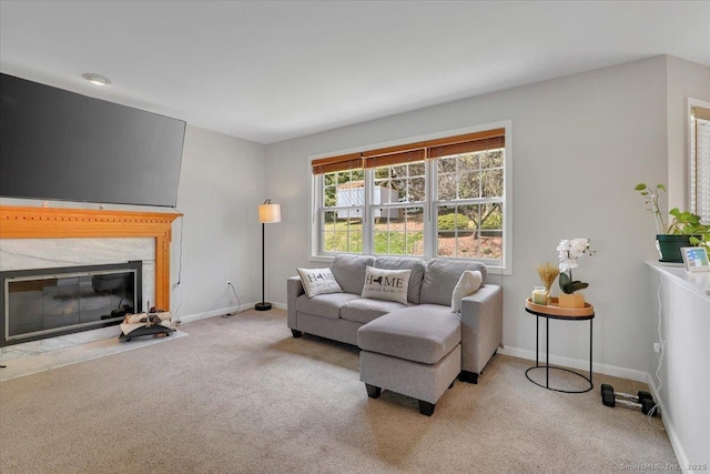 carpeted living area featuring baseboards and a premium fireplace