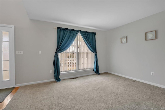carpeted empty room with visible vents and baseboards
