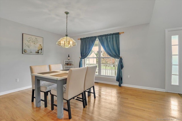 dining area with a chandelier, plenty of natural light, and light wood-type flooring