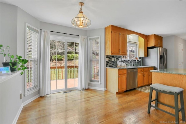 kitchen featuring light wood finished floors, appliances with stainless steel finishes, an inviting chandelier, and visible vents