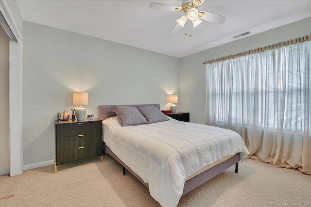 bedroom featuring baseboards, light colored carpet, ceiling fan, and visible vents