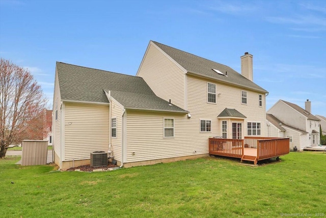 back of house with roof with shingles, a chimney, cooling unit, a yard, and a deck