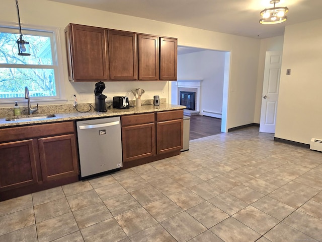 kitchen with light stone countertops, baseboard heating, a sink, light tile patterned floors, and stainless steel dishwasher