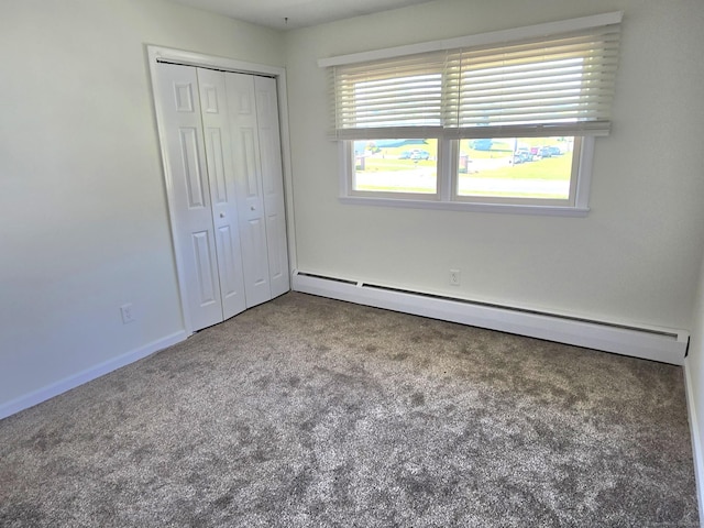 unfurnished bedroom featuring a closet, carpet, baseboards, and baseboard heating