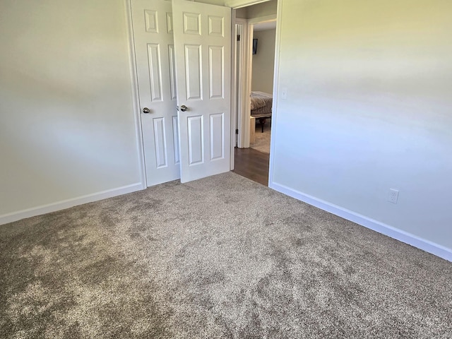 unfurnished bedroom with carpet floors and baseboards