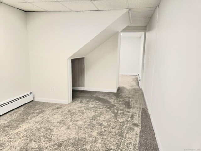 additional living space with carpet floors, baseboards, and a baseboard heating unit