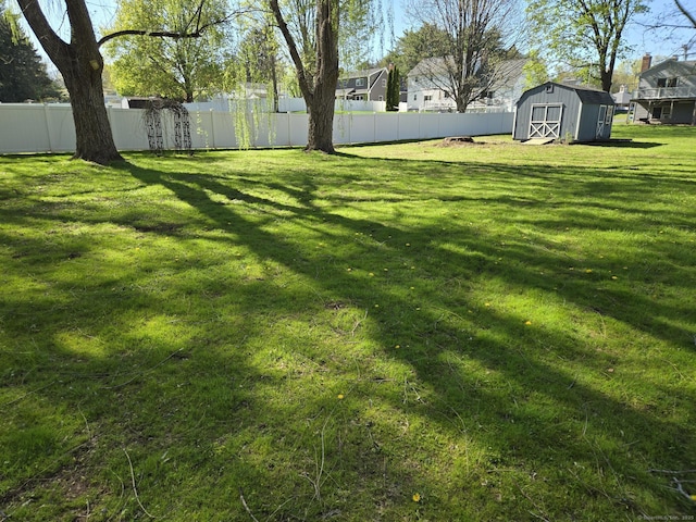 view of yard with a storage unit, an outdoor structure, and fence
