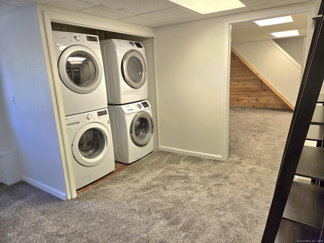 laundry room with wooden walls, stacked washer and dryer, laundry area, carpet floors, and baseboards