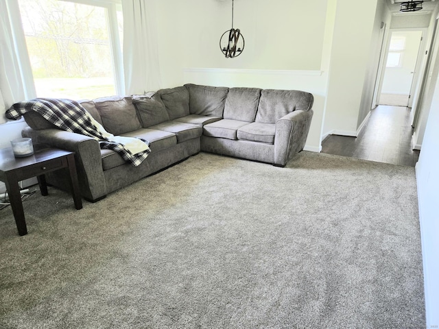living room featuring carpet and a notable chandelier