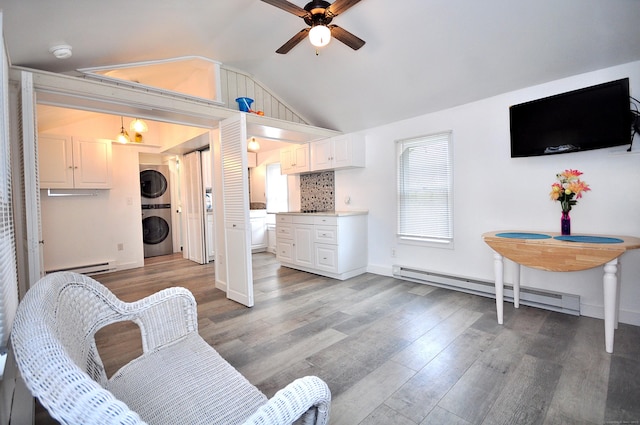 300 Mile Creek Rd, Old Lyme, CT 06371 - living area featuring estacked washer and dryer, ceiling fan, vaulted ceiling, a baseboard radiator, and wood finished floors