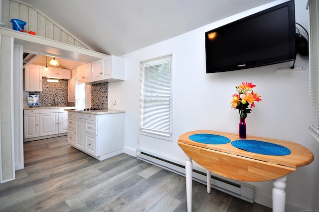 300 Mile Creek Rd, Old Lyme, CT 06371 - kitchen with a baseboard radiator, backsplash, vaulted ceiling, light wood-type flooring, and white cabinetry