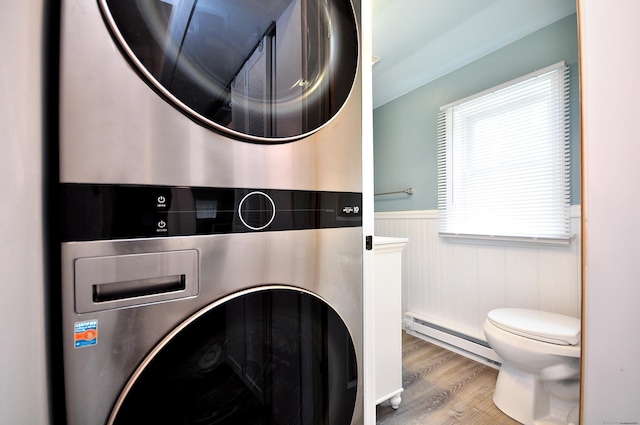 300 Mile Creek Rd, Old Lyme, CT 06371 - washroom with stacked washer / drying machine, a baseboard radiator, a wainscoted wall, and wood finished floors