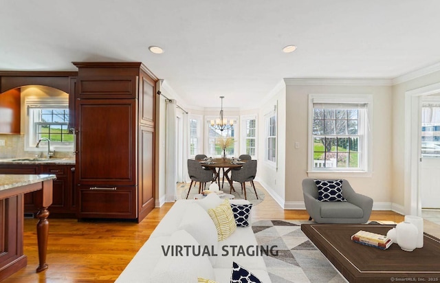 569 Lake Winnemaug Rd, Watertown, CT 06795 - living room with recessed lighting, light wood finished floors, an inviting chandelier, crown molding, and baseboards