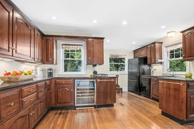 15 Devonshire Dr, Darien, CT 06820 - kitchen with beverage cooler, black appliances, dark countertops, light wood-style flooring, and plenty of natural light
