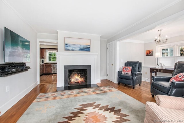 15 Devonshire Dr, Darien, CT 06820 - living area featuring wood finished floors, a warm lit fireplace, a chandelier, beverage cooler, and crown molding