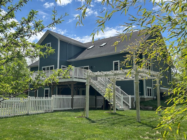 rear view of house with a wooden deck and roof with shingles