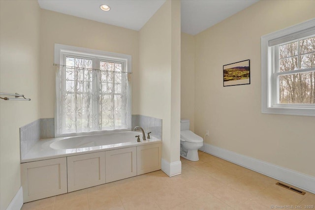 bathroom featuring toilet, a garden tub, baseboards, and tile patterned flooring