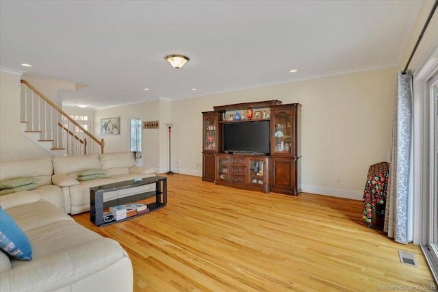 living room featuring wood finished floors, stairs, ornamental molding, baseboards, and recessed lighting